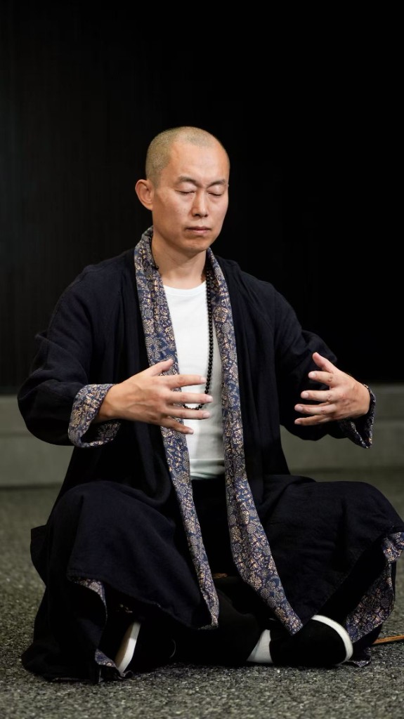莫子老师盘坐抱圆，练习站桩。