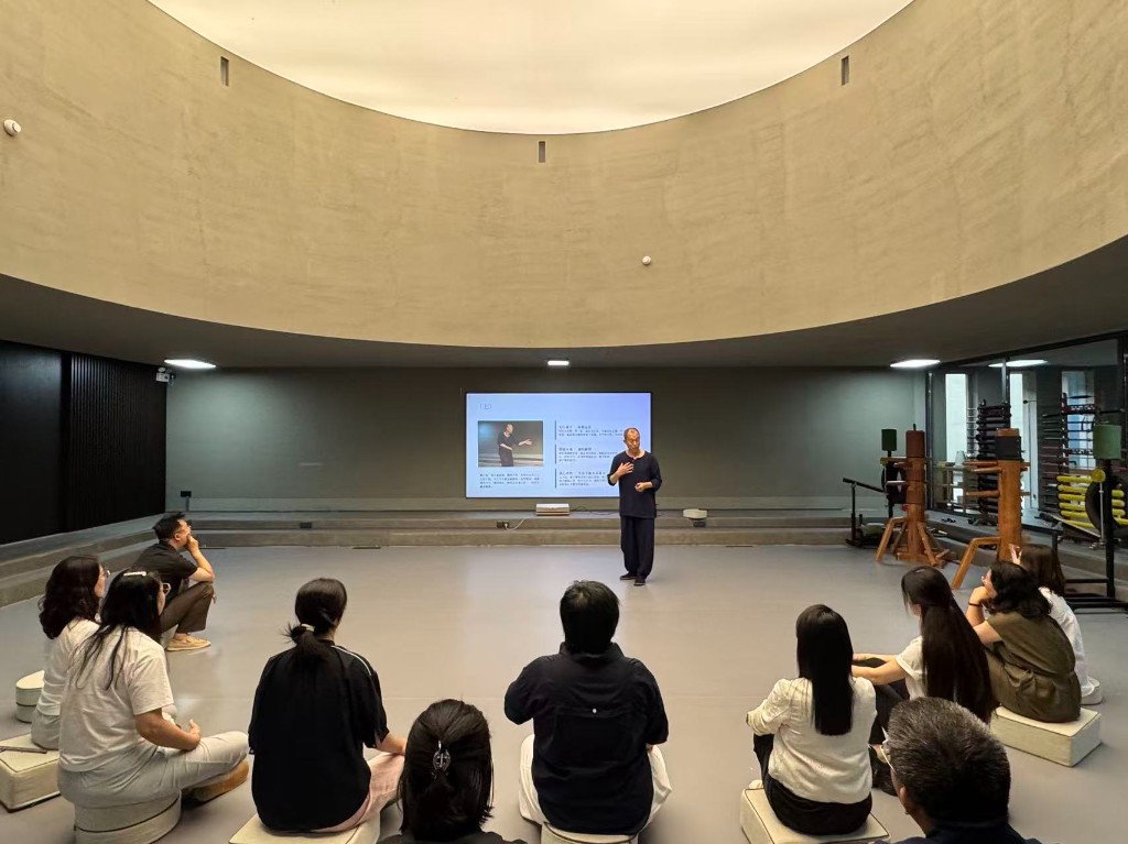 莫子老师在北京场馆授课，学员席地而坐。